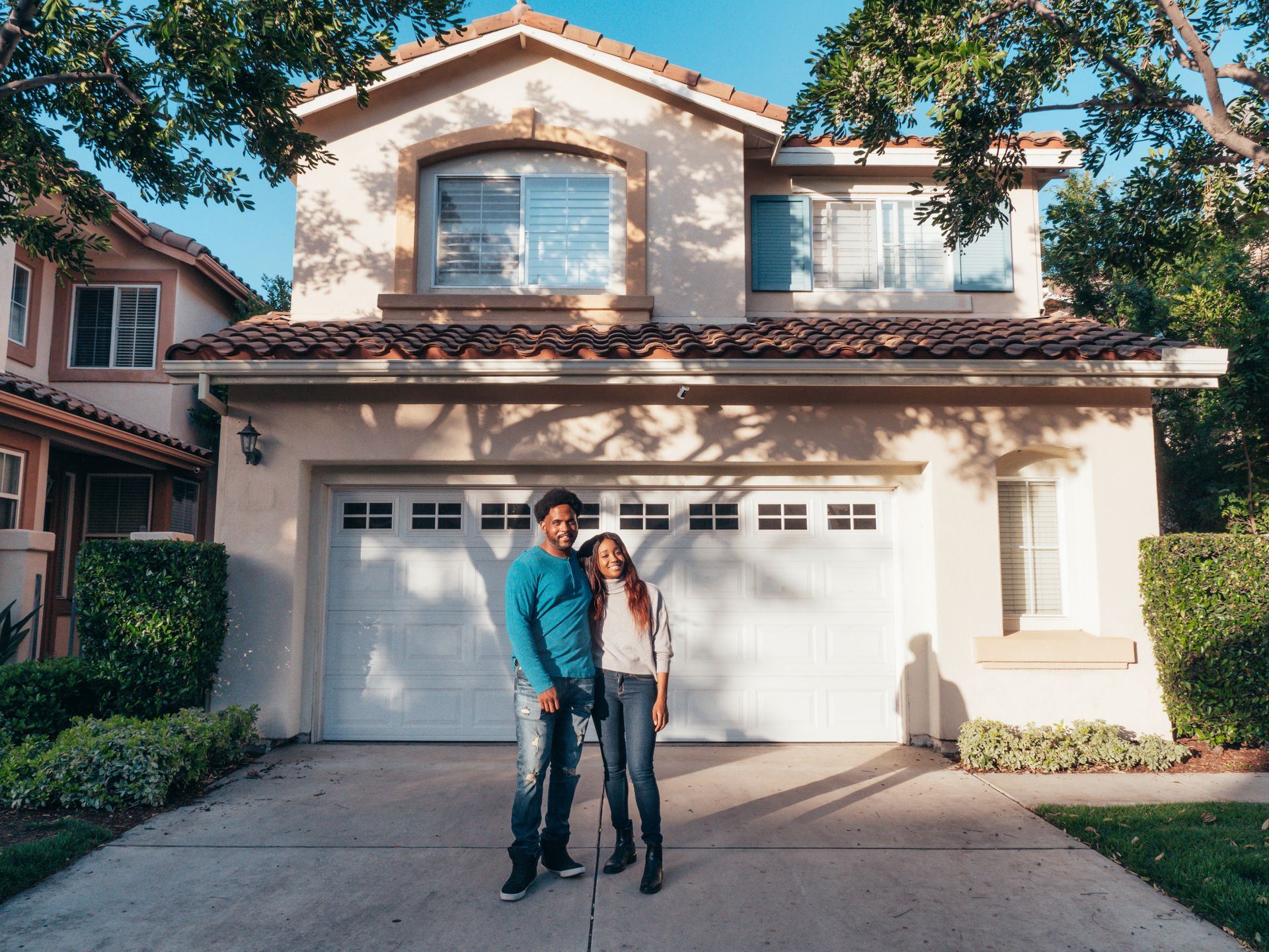 A couple standing in front of their new house
